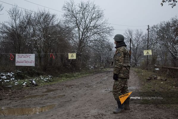 Военнослужащий армии обороны Карабаха на одной из улиц в селе Тагавард Мартунинского района (11 декабря 2020). Карабах - Sputnik Армения