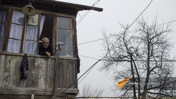 Пожилой мужчина смотрит из окна своего дома в селе Тагавард Мартунинского района (11 декабря 2020). Карабах - Sputnik Армения