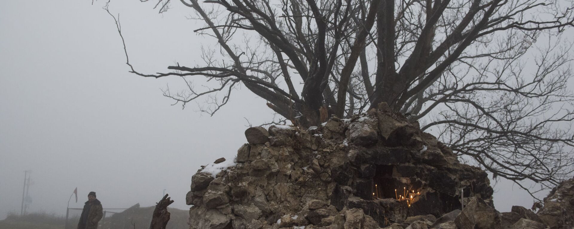 Свечи на камнях возле дерева на одной из улиц в селе Тагавард Мартунинского района (11 декабря 2020). Карабах - Sputnik Армения, 1920, 03.12.2021