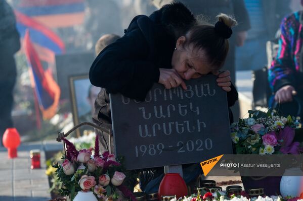 Женщина скорбит на могиле в пантеоне Ераблур (19 декабря 2020). Еревaн - Sputnik Армения