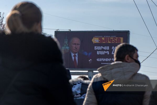Участники Шествия памяти на фоне баннера с изображением Владимира Путина по дороге в пантеон Ераблур (19 декабря 2020). Еревaн - Sputnik Армения