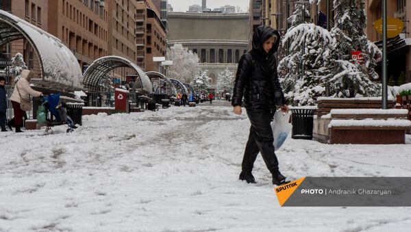Женщина проходит по неочищенному Северному проспекту (24 декабря 2020). Еревaн - Sputnik Армения