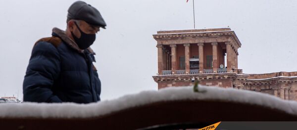 Мужчина проходит мимо скамьи на площади Республики (24 декабря 2020). Еревaн - Sputnik Արմենիա