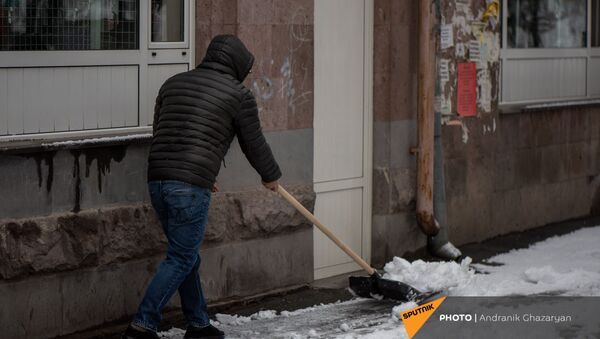 Молодой человек очищает от снега улицу - Sputnik Արմենիա