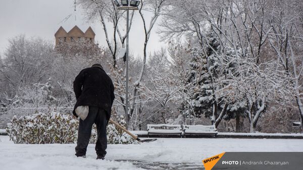 Мужчина очищает от снега улицу - Sputnik Արմենիա