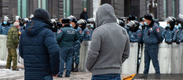 Молодые люди наблюдают за спором активиста и полицейских у Дома правительства (24 декабря 2020). Еревaн - Sputnik Արմենիա