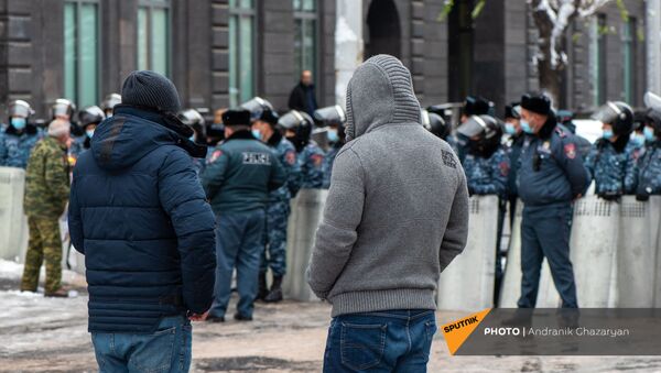 Молодые люди наблюдают за спором активиста и полицейских у Дома правительства (24 декабря 2020). Еревaн - Sputnik Արմենիա