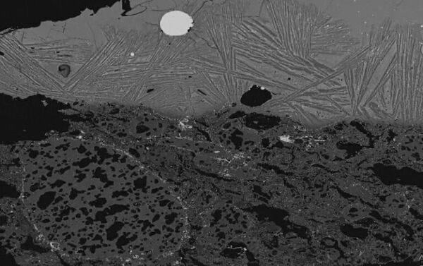Изображение шлака внутри тигля, полученное с помощью сканирующего электронного микроскопа, с серебристым стальным пятном, видимым в центре вверху - Sputnik Армения