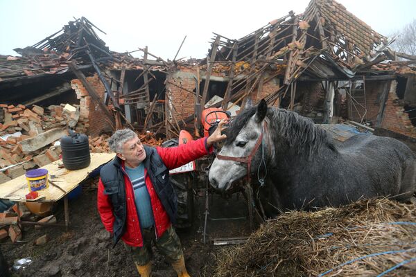 Фермер со своей лошадью у разрушенного дома после землетрясения в Хорватии  - Sputnik Армения