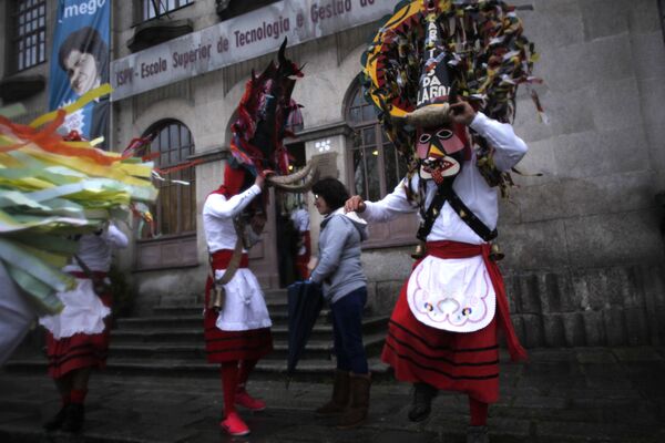 Участники фестиваля в бычьих масках и традиционных костюмах в Португалии - Sputnik Армения