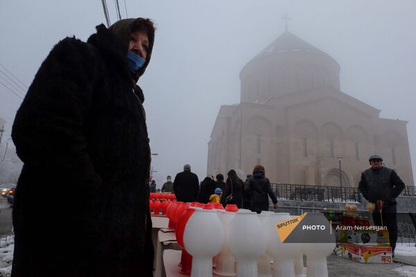 Սուրբ Խաչ եկեղեցու մոտ Ճրագալույցի պատարագի ժամանակ կանթեղներ վաճառող կինը, (2021, հունվարի 5), Երևան  - Sputnik Արմենիա
