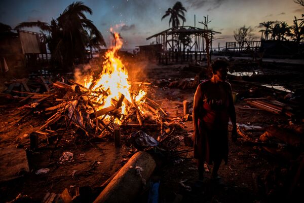 Люди сжигают мусор, оставшийся после урагана Йота в Бильви, Никарагуа - Sputnik Армения