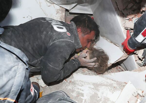 Турецкие спасатели вытаскивают ребенка из под обломков после землетрясения в Измире - Sputnik Армения