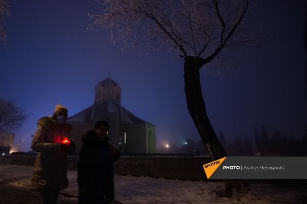Люди с лампадами у церкви Святого Просветителя в Рождественский сочельник (5 января 2021). Еревaн - Sputnik Армения