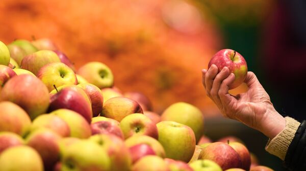 Яблоки в руке покупателя в магазине - Sputnik Армения