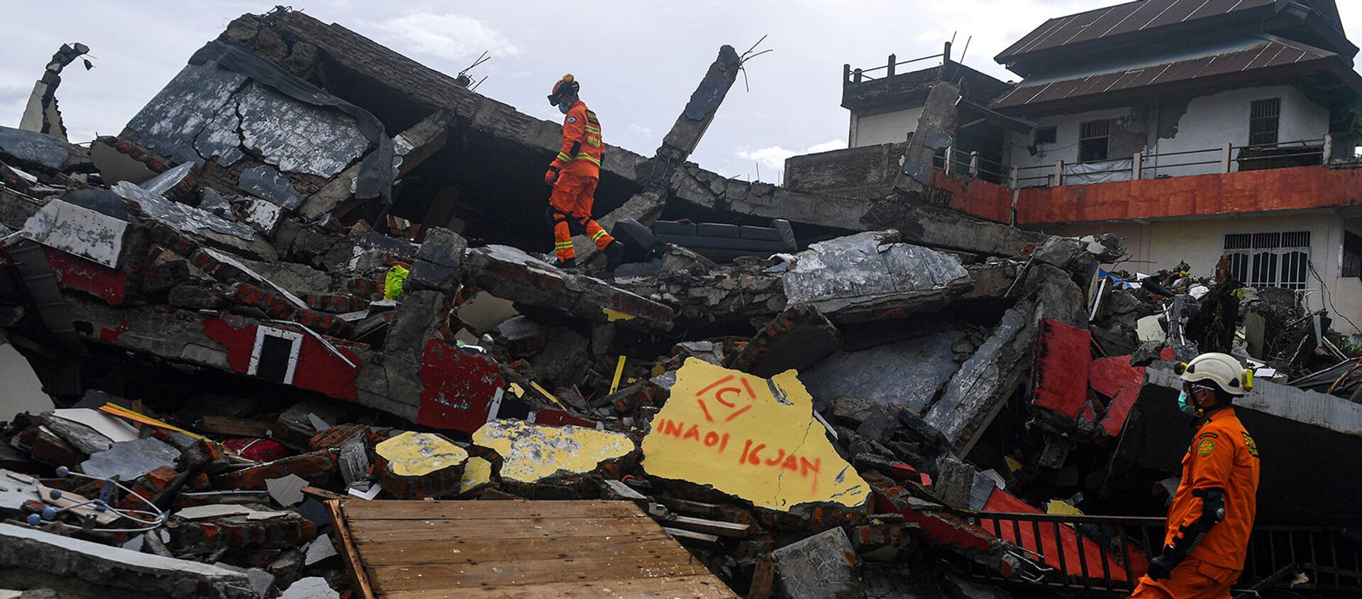 Поисково-спасательный персонал осматривает обрушившееся здание после землетрясения в Мамуджу (16 января 2021). Индонезия - Sputnik Արմենիա, 1920, 16.01.2021