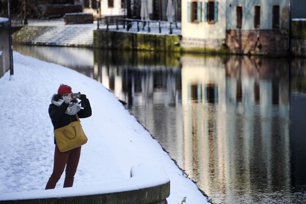 Женщина фотографирует заснеженный район Петит-Франс в Страсбурге, восточная Франция - Sputnik Армения