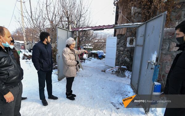 Мать мужчины, взявшего в заложники 3-летнего сына, Нвард, вместе с сотрудниками следственного отдела у ворот дома (27 января 2021). Еревaн - Sputnik Армения