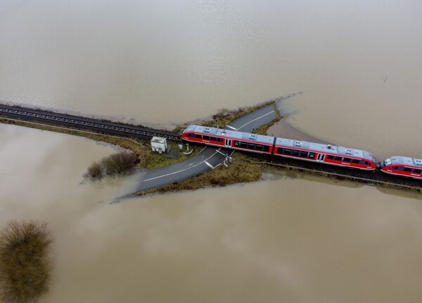 Поезд проезжает по железной дороге на затопленной местности в Германии  - Sputnik Армения
