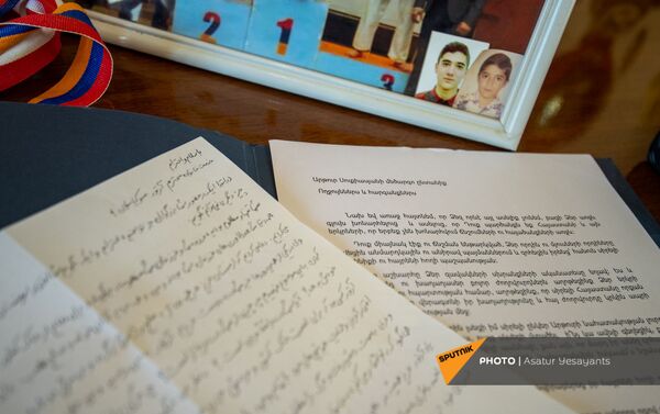 Наградной документ к золотой медали, переданной семье погибшего в карабахской войне спортсмена Артура Сукиасяна от иранского спортсмена - Sputnik Армения