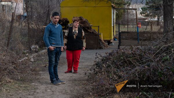 Жительница села Неркин Ханд в Сюникской области Гюльнара Оромсимян с сыном на фоне своего домика - Sputnik Արմենիա