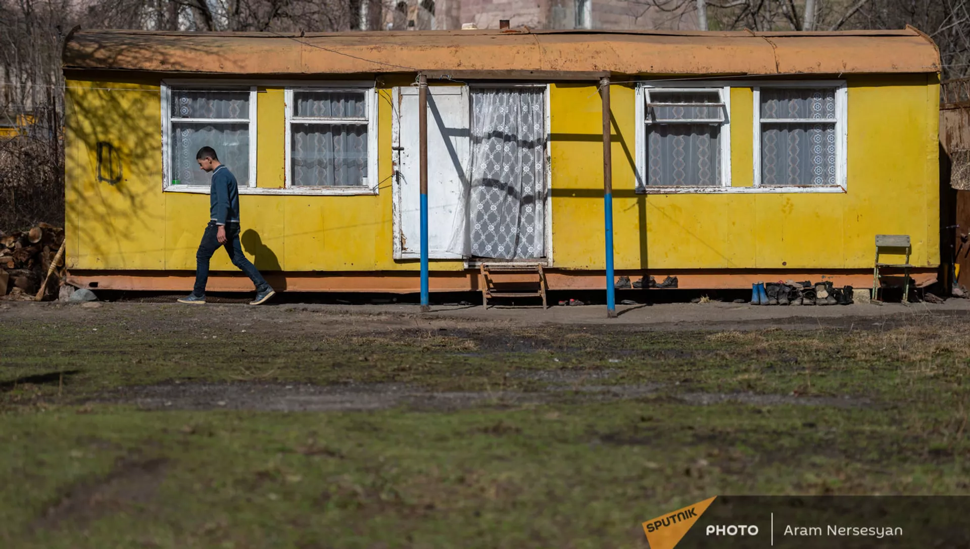 Молодой житель села Неркин Ханд в Сюникской области на фоне своего домика