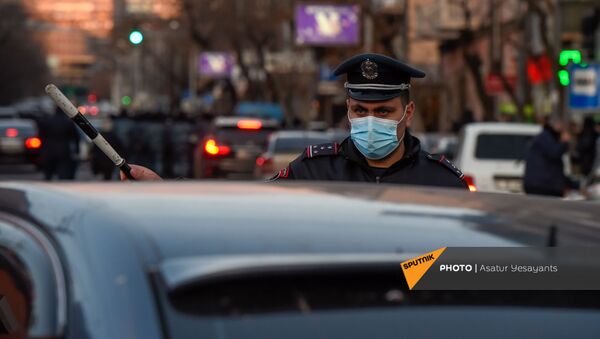 Полицейский регулировщик указывает помогает автомобилистам во время шествия протеста оппозиции по центральным улицам столицы (23 февраля 2021). Еревaн - Sputnik Армения