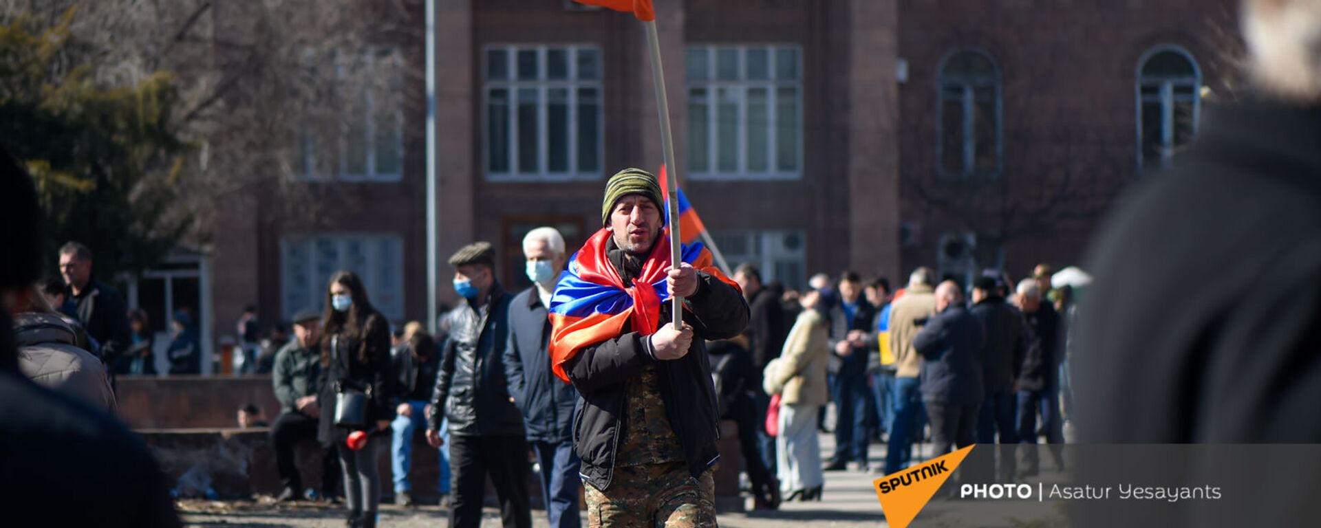 Оппозиционер с флагами на плечах и в руках перед началом акции оппозиции на перекрытом проспекте Баграмяна (26 февраля 2021). Еревaн - Sputnik Արմենիա, 1920, 27.02.2021