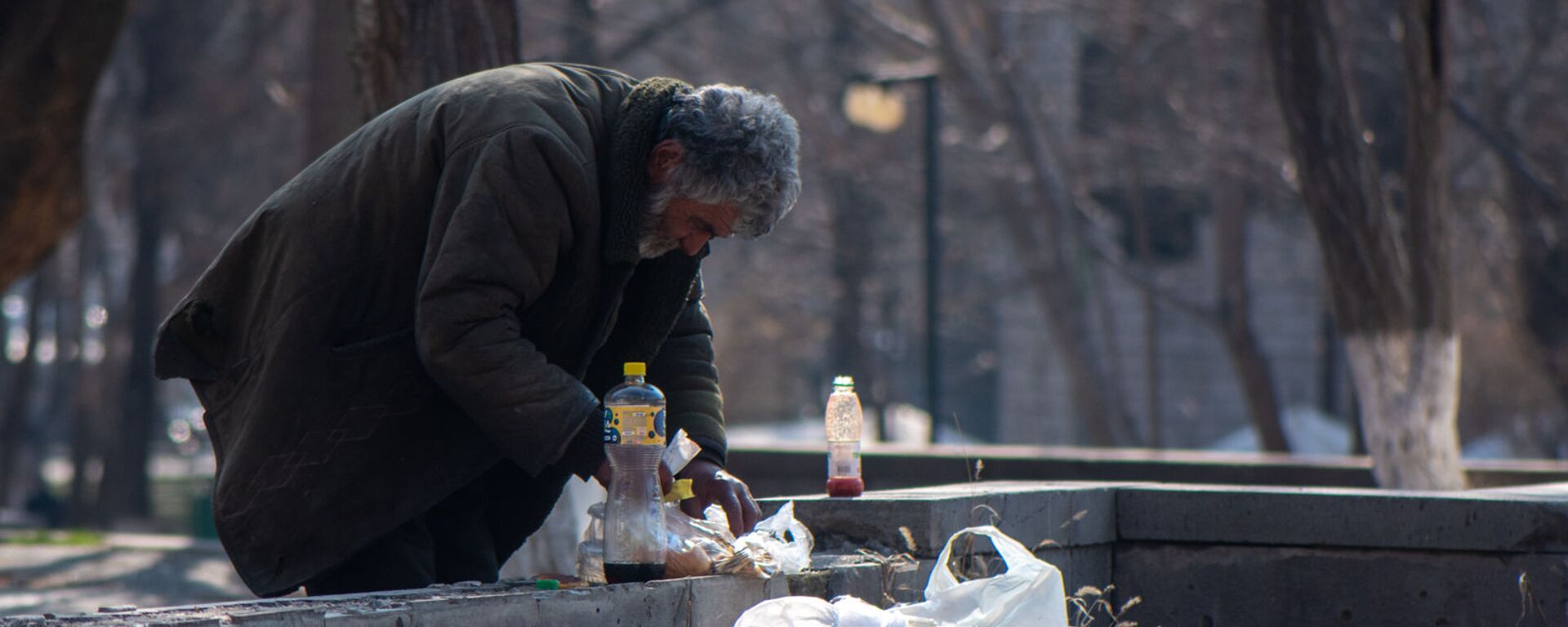 Бездомный мужчина обедает в городском парке - Sputnik Армения, 1920, 14.10.2021