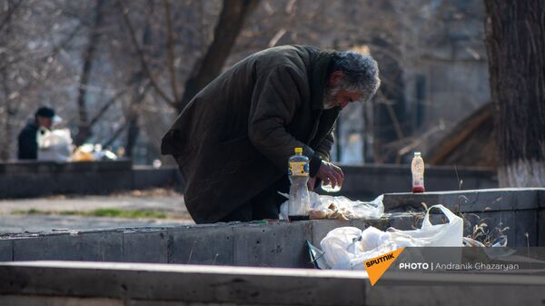 Бездомный мужчина обедает в городском парке - Sputnik Армения