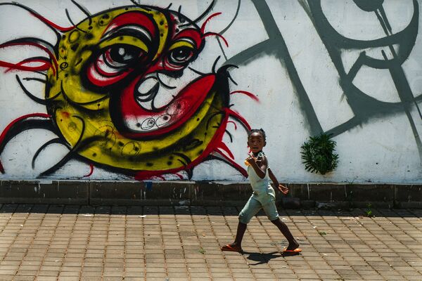 Ребенок у граффити с изображением COVID-19 в Совето, ЮАР - Sputnik Армения