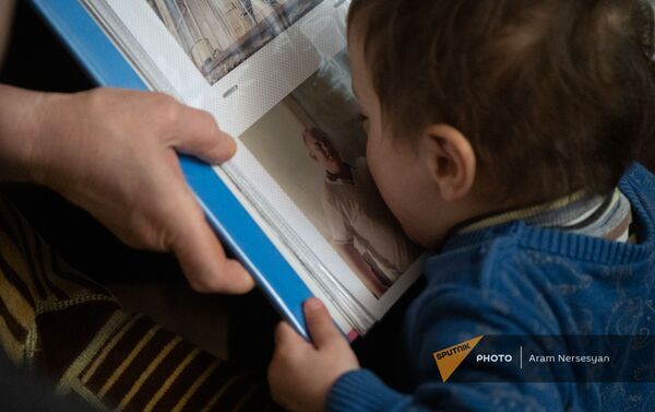 Маленький племянник целует фотографию погибшего в карабахской войне Тиграна Ханумяна - Sputnik Армения