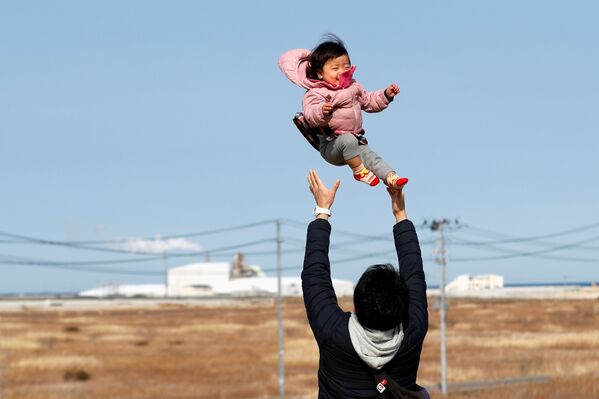 Потерявший родных во время землетрясения 2011 года отец с ребенком в префектуре Фукусима  - Sputnik Армения
