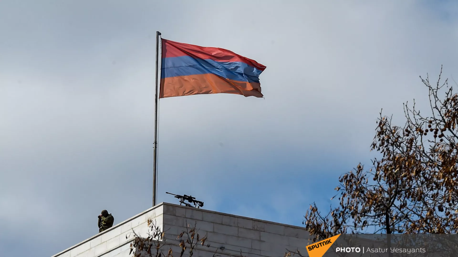 Сотрудник правоохранительных органов рядом с винтовкой на крыше здания МИД Армении (13 марта 2021). Еревaн