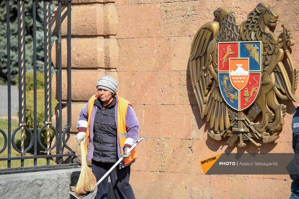 Сотрудница муниципальной службы у входа в резиденцию президента Армении (13 марта 2021). Еревaн - Sputnik Армения