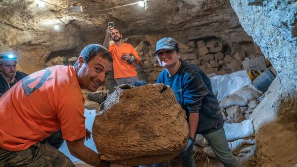 Израильские археологи с древней корзиной, найденной в пещере Мурабаат в Иудейской пустыне недалеко от Мертвого моря - Sputnik Արմենիա