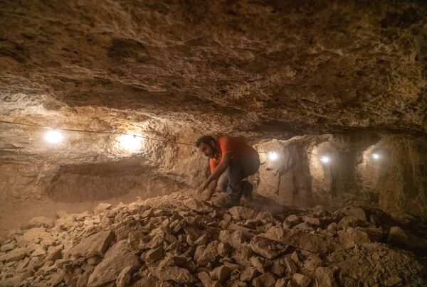 Израильский археолог во время раскопок в пещере в Иудейской пустыне - Sputnik Армения