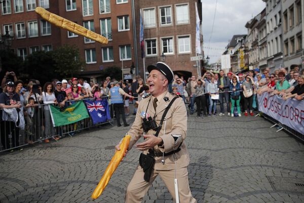 Мужчина в костюме французского жандарма шестидесятых годов жонглирует двумя багетами в Дюссельдорфе, Германия - Sputnik Армения