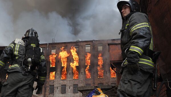 Сотрудник пожарной службы у здания фабрики Невская мануфактура (12 апреля 2021). Санкт-Петербург - Sputnik Армения