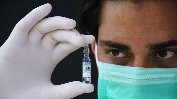 Медицинский работник держит в руках ампулу с российским препаратом от коронавирусной инфекции Sputnik V - Sputnik Արմենիա