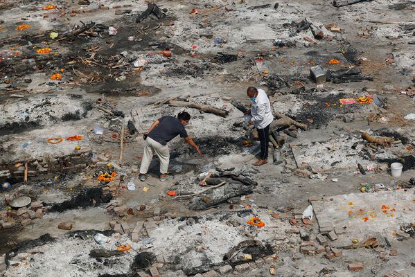 Люди собирают прах родственника после массовой кремации в Нью-Дели, Индия - Sputnik Армения