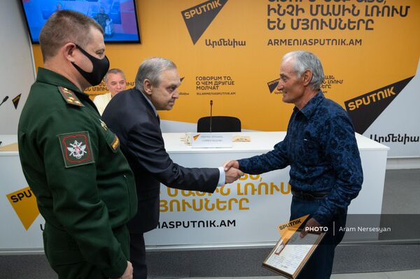 Георгий Мурадов вручает сертификат на медаль Самвелу Мадояну во время телемоста с Симферополем в пресс-центре Sputnik Армения (30 апреля 2021). Еревaн - Sputnik Армения