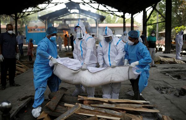 Медицинские работники и родственники несут тело мужчины, умершего от коронавируса в Нью-Дели - Sputnik Армения