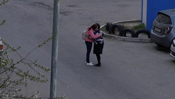 Женщина обнимает покинувшую гимназию № 175 школьницу после перестрелки (11 мая 2021). Казань - Sputnik Армения