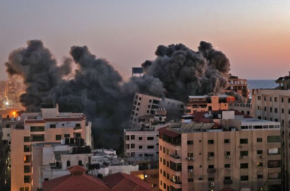 Пожарные тушат горящие многоквартирные дома после израильских авиаударов в городе Газа - Sputnik Армения