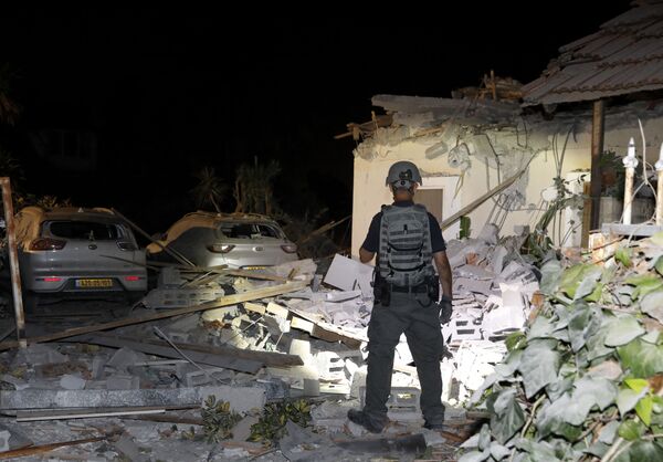 Офицер службы безопасности Израиля осматривает повреждения дома в Йехуде, недалеко от Тель-Авива - Sputnik Армения