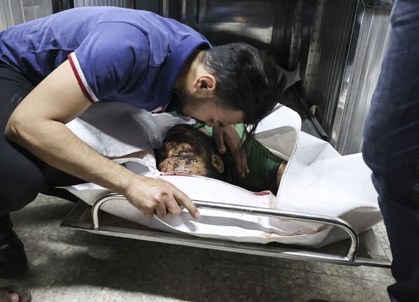 Палестинец оплакивает тело своего родственника в морге больницы Аль-Шифа в городе Газа после израильских авиаударов по целям в секторе Газа (12 мая 2021).  - Sputnik Արմենիա