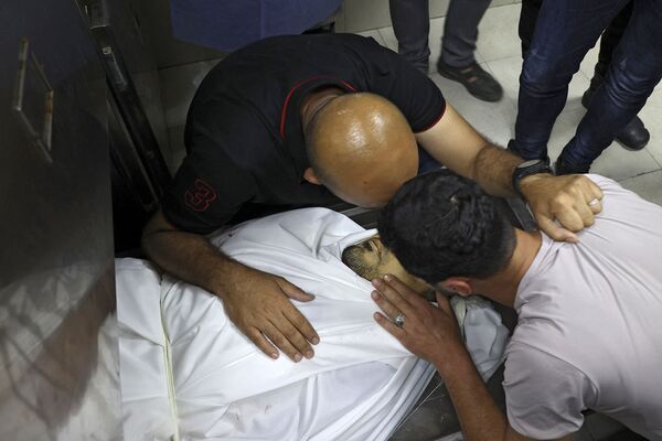 Палестинцы скорбят по умершему родственнику в морге индонезийской больницы в Бейт-Лахии (15 мая 2021). Сектор Газа - Sputnik Армения