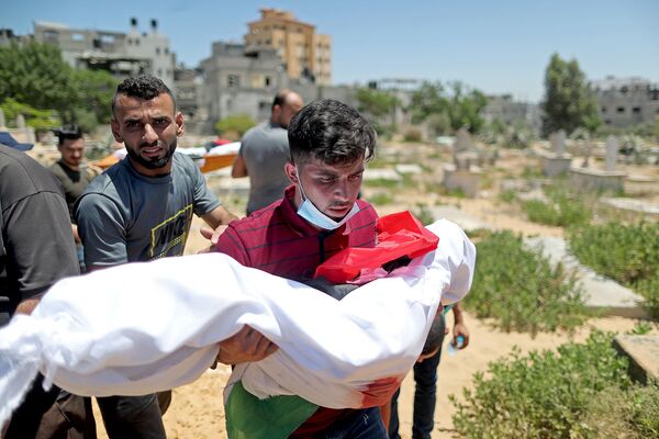 Իսրայելապաղեստինյան հրաձգության ժամանակ սպանված Ալ-Հադիդի ընտանիքի երեխայի մարմինը տեղափոխող տղամարդը (մայիսի 15, 2021). Գազայի հատված - Sputnik Արմենիա