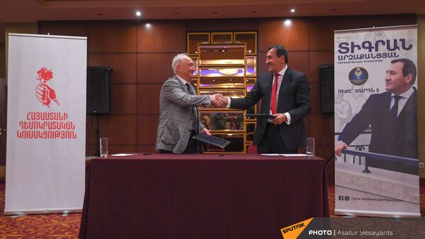 Лидер Армянской демократической партии Арам Саркисян и основатель благотворительного фонда Тигран Арзаканцян пожимают друг другу руки во время церемонии подписания меморандума (18 мая 2021). Еревaн  - Sputnik Армения